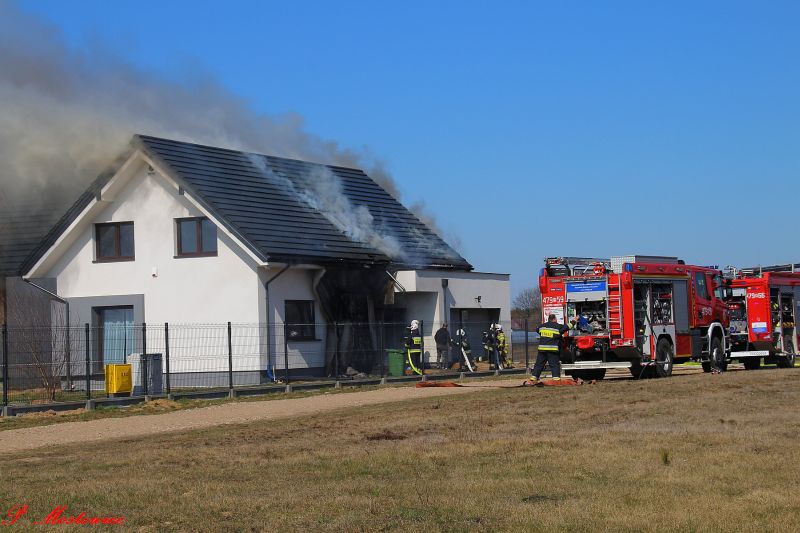 Płonący dach domu gaszą strażacy